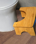 Foldable Bamboo Toilet Stool For Adults, 7.5 Inch Squat Aid next to white toilet, showing bamboo texture and non-slip strip.