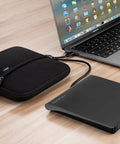 External CD DVD Drive For Laptop And Mac With Case USB 3 Type-C Plug And Play For Reading Burning And Watching CDs And DVDs On The Go Wide Compatibility Compact Portable Design, black drive with carrying case beside MacBook