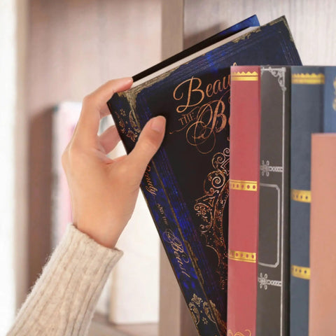 Hand reaching for Hideaway Book Safe With Combination Lock A Real Stash Box Diversion Safe Disguised As A Novel For Valuables Such As Cash Jewelry And Documents Big Hidden Storage Beauty And The Beast Theme on bookshelf.