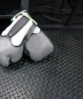 Diamond Plate Rubber Flooring Roll 3 mm Thick 4 Ft By 2 Ft Black Durable Industrial Grippy Floor Mat For Slippery Surfaces Outdoor Walkways And Equipment Protection with boxing gloves on top.