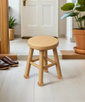 Wooden stool in a modern room setting with plant and shoes nearby, showcasing 4 Pack Round Bun Wood Furniture Legs 5cm Lift For Cabinets Benches And Sofas Easy Install Replacement Feet In Modern Solid Wood Finish To Freshen Up Your Home Decor.