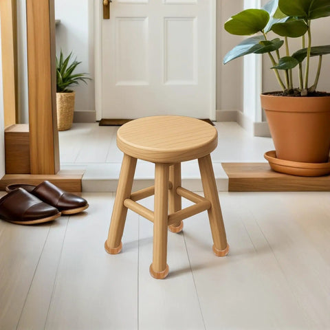 Round stool with light wood finish, placed in an entryway near a plant and shoes, reflecting modern home decor.