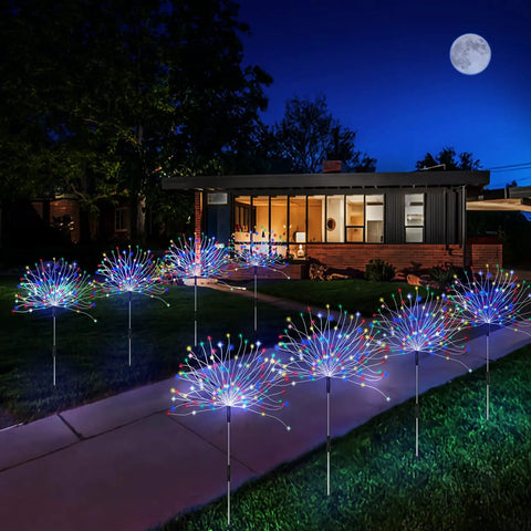Four Pack Solar Garden Lights With 120 LED Copper Wire Waterproof Fireworks Design Flexible Stakes For Pathway And Lawn Remote Included 8 Modes Colorful Glow For Outdoor Backyard Ambiance illuminating a pathway.