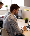 Office desk with a Clear 8 Inch Acrylic Name Plate Holder 2x8 Inch Wall Sign Display Pack of 20 mounted on a wall showing 'Greer'