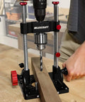Beefy Pro Grade Portable Drill Press Drilling Guide With One Half Inch Chuck, shown in use on wooden plank in workshop.