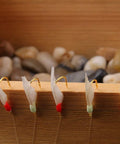 Glow In The Dark Saltwater Fishing Bait Rig Set 15 Pack With Real Fish Skin Sharp Hooks on wooden background