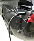Plugged in charger on Tesla vehicle showing All Season Silicone Cover For Tesla Nacs Ev Charger Port Slick Flexible Seal Easy Pop On Off Design fending off grime.