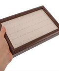 Solid Wood Earring Organizer And Ring Keeper Tray With Thirty Open Slots For Stashing Bracelets And Chains In A Rich Walnut Finish held in hand.
