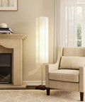 Gyoza Floorchiere Floor Lamp Tall 67 Inch Standing Light in a living room with walnut rubber wood base, white rice paper shade next to armchair.
