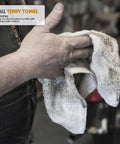 Person holding a white terry rag, 12x12 inches, 100 percent ring spun cotton, shown in a garage setting
