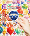 Hand holding watercolor hot air balloon sticker from the Watercolor Hot Air Balloon Sticker Pack Dope 50 Designs Waterproof Vinyl For Journaling Laptops Water Bottles Planners Scrapbooks Phone Cases Luggage Skateboards And More Adventure Aesthetic Decor.