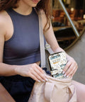 Woman placing Leather RFID Wallet Clutch For Women With Built In Mirror And Zippered Coin Pocket Long Purse into a bag
