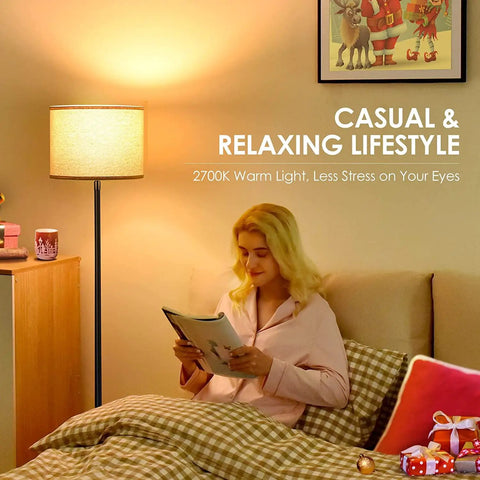 Woman reading in a cozy room with 58 inch floor lamp standing bright light with beige lampshade and easy on off foot pedal simple pole style