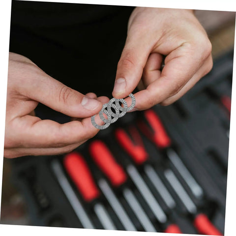 Premium 20 Piece Manganese Lock Washers With Double Wedge Tooth Design held between fingers above a tool kit.