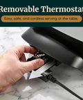 Hand adjusting removable thermostat on compact electric skillet with dual nonstick coating, 600W power, 2.5-quart capacity.