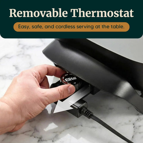 Hand adjusting removable thermostat on compact electric skillet with dual nonstick coating, 600W power, 2.5-quart capacity.