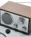 Aluminum Speaker Isolation Pads For Durable Vibration Control And Noise Reduction next to vintage speaker on table