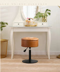 360 Degree Swivel Vanity Stool With Hidden Storage, whiskey brown faux leather, in front of white vanity table in makeup room.