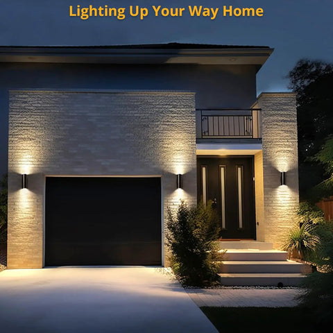Modern Outdoor Wall Lights Up and Down Cylinder Sconce Matte Black Pack of 2 illuminating a home’s garage and entryway at night