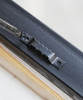 Close-up of Top Shelf Heavy Duty Black Sawtooth Picture Hangers attached to wood frame, supports 20 lbs.