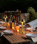 Outdoor dining table with cordless gold battery operated table lamps for dining ambience, rechargeable dimmable night light.