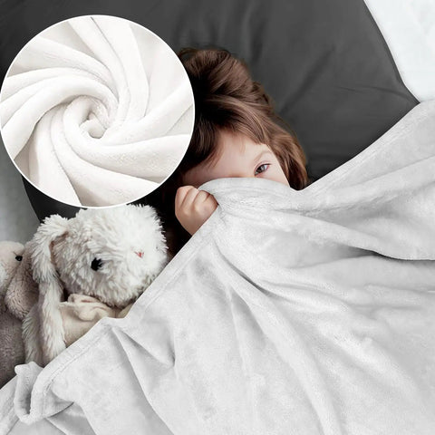 Child snuggled under Cozy As Heck Winter Train Blanket For Adults And Kids Flannel Throw with plush toys in bed.