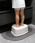 Heck Of A Sturdy Kids Step Stool With Super Grippy Non Slip Feet For Little Ones Reaching The Bathroom Sink Or Finishing Potty Training Without Any Wobbles, compact white stool in use.