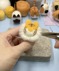 Hands creating a faceless animal figure using the Beginner Friendly Needle Felting Kit For Adults Who Love Getting Crafty.