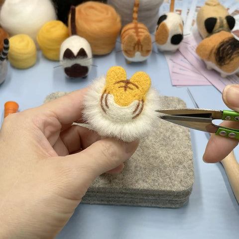 Hands creating a faceless animal figure using the Beginner Friendly Needle Felting Kit For Adults Who Love Getting Crafty.