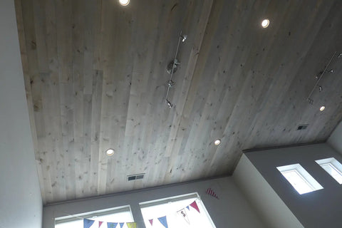 Slick Water Based Aging Wood Stain Yields Authentic Driftwood Gray Finish on a ceiling with recessed lights.