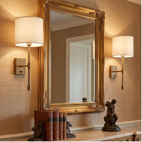 Fabric Shade Wall Sconce Vintage Brass Metal Lamp Bedside Indoor Lighting beside a vintage mirror and books.