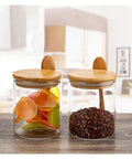 Keep Your Daily Grind Hella Fresh In This Rock Solid Clear Glass Coffee Canister And Airtight Food Storage Jar With Tightly Sealed Lid And Handy Spoon For Tea Sugar Salt Organization. Two glass jars with bamboo lids containing colorful items and spices.