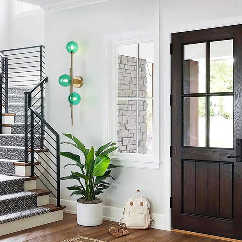 Dope Gold Long Strip 3 Light Globe Vanity Wall Sconce With Green Glass Shades Minimalist Mirror Bathroom Lighting Modern Contemporary Wall Fixture For Vanity And Mirror Area installed in hallway next to stairs.