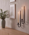 Built Tough Matte Black Farmhouse Wall Candle Sconce Holder Set of Two Heavy Duty Thick Iron Metal Wall Decor with Scratch Proof Finish for Warm Ambient Vibes, featuring two lit candles against a wall.