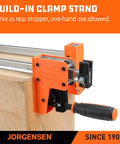 Close-up of 48-Inch Heavy Duty Bar Clamps Set With Parallel Jaws, highlighting reversible head on wood panel, orange and black design.