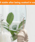 Forty Pack Mini Clear Suction Cup Hooks With Sleek Metal Utility Rings holding bath accessories on a mirror with moisture.