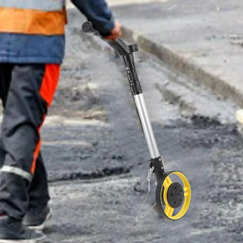 Jiawu Digital Display Distance Measuring Wheel Foldable Hand Push Roller Rangefinder measuring distance on asphalt surface.