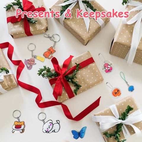 Brown wrapped gift boxes with red ribbons and Shrink Dink keychain kit charms, including animal and butterfly designs.