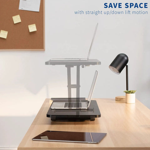 Black 28 Inch Standing Desk Converter Sit To Stand Monitor Riser With Scissor Lift Height Adjustment on a desk