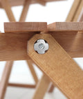 Close-up of Heavy Hitting 1/4-20 T Nuts Twenty Five Pack, Top Notch 304 Stainless Steel four jaw tee fastener on wooden furniture.