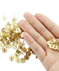 Top Shelf Gold Flat Head Thumb Tacks 100 Pack Kickin Push Pins For Bulletin Boards and Office Setup solid metal pins in hand.