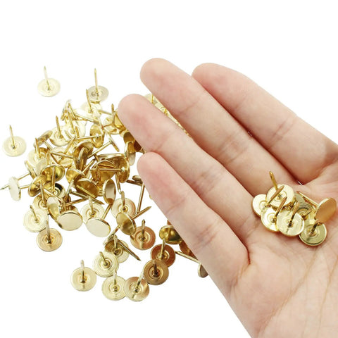 Top Shelf Gold Flat Head Thumb Tacks 100 Pack Kickin Push Pins For Bulletin Boards and Office Setup solid metal pins in hand.