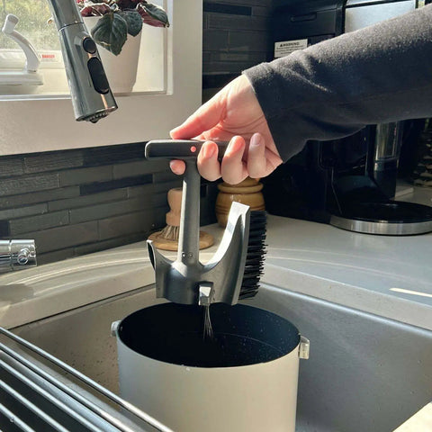 Using the Infinity Brush from the Double Your Kitchen Composting Capacity With Eco 3 Bucket And Infinity Brush Pack over a sink.