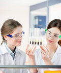 Two women in lab coats wearing 100 Pack Bulk Safety Glasses Featuring Bully Proof Polycarbonate Lenses And Heavy Duty Scratch Protection For Job Sites And Weekend Rigs Rainbow Mix Set.