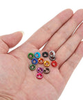 A hand holding a set of multi-colored anodized M3 finishing countersunk washers, 10 pack, for RC FPV drones and PC mechanical accessories.