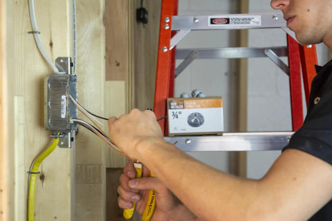 Electrician installing 3/8 To 1/2 Inch Knockout Non-Metallic Push-In Connector Gray 100 Pack Model 75105B in electrical box
