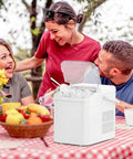 Grab And Go Countertop Ice Maker With Handle Portable Ice Machine at picnic with basket and scoop on a red checkered table