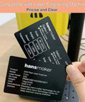 Person holding shiny business cards with technical specifications in front of yellow laser engraver.
