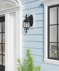 Frontenac 1 Light Outdoor Wall Lantern with clear beveled glass shades, black finish mounted on blue house exterior