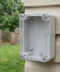 Top-Tier Waterproof Electrical Box Set With Abs Cover For Outdoor Security Modules And Internal Circuits To Keep Stuff Dry And Safe From Rain Sun Or Dust mounted on a wall with raindrops on it.